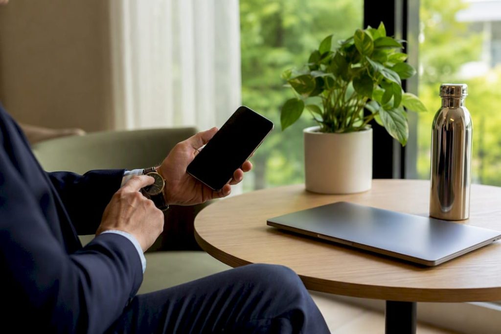 Händer som håller i en telefon och kollar på klockan